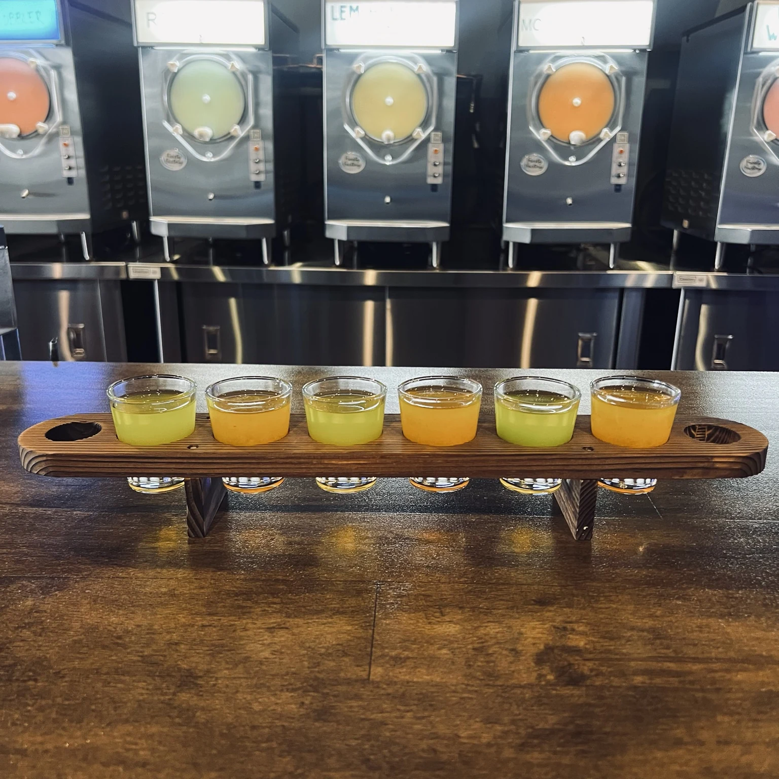 Cold Cocked pickle shot flight served on a six-glass wooden flight board